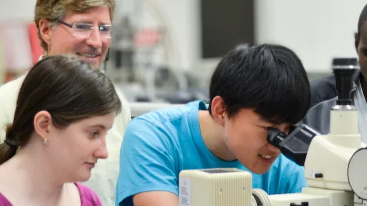 Carmen lab students using microscope