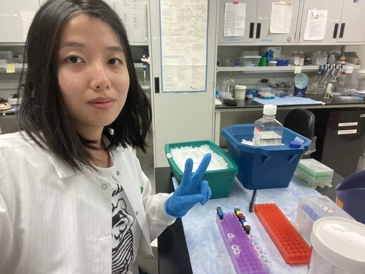 female with lab coat on and blue gloves