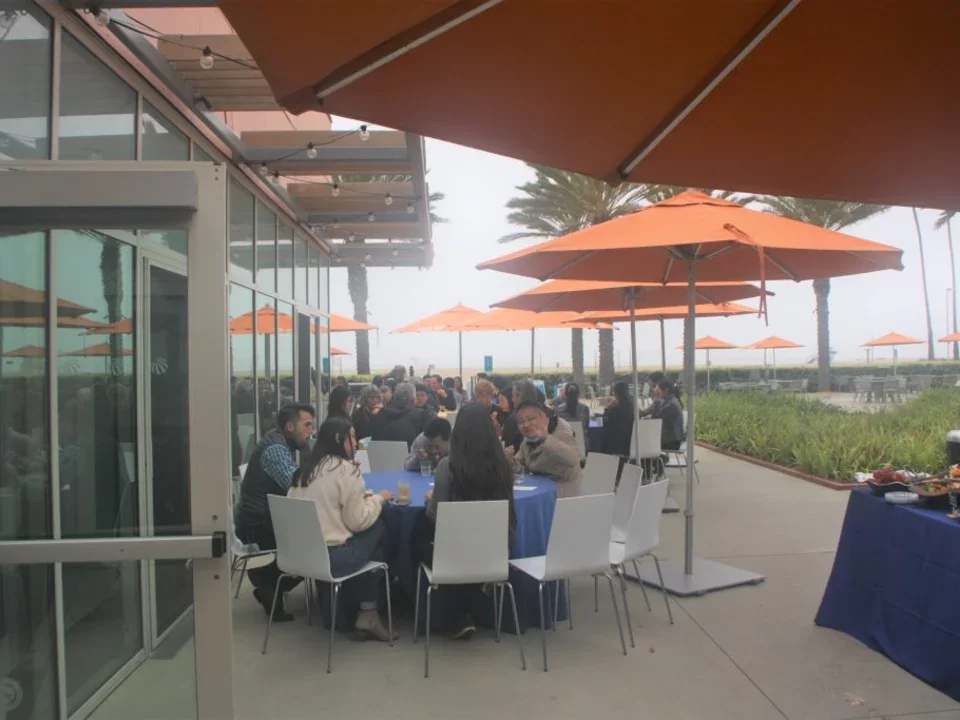 Retreat attendees having a meal outside under umbrellas