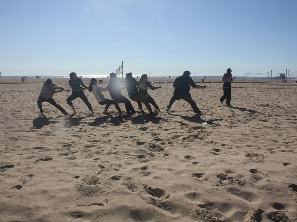 game of tug-o-war in sand between students and faculty