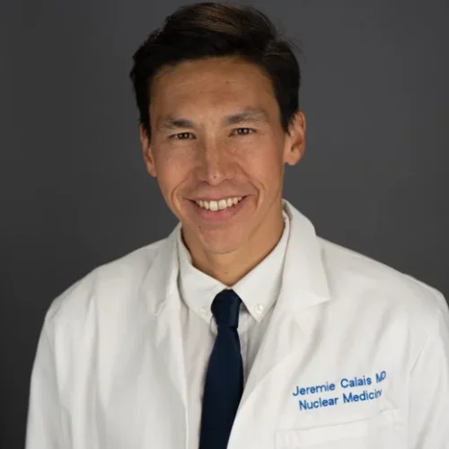 Man with short dark hair, black necktie and white lab coat