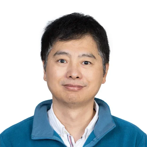 Man with short black hair and teal jacket