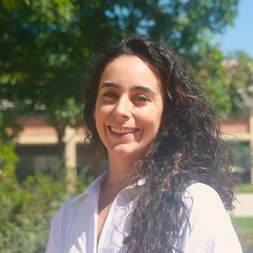 woman with long dark hair wearing a white blouse