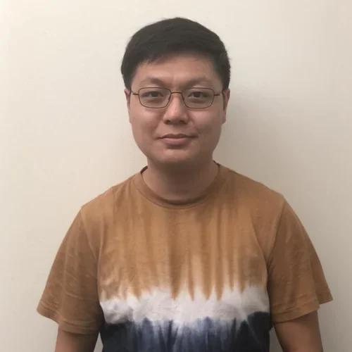 male with glass in gold shirt