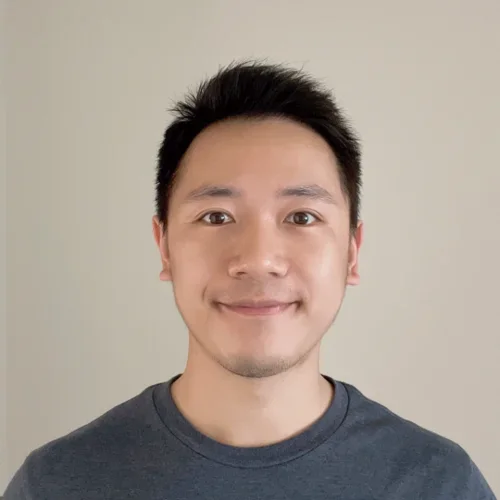 man with short dark hair smiling wearing a dark t-shirt