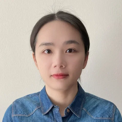 woman with dark hair wearing blue denim button shirt