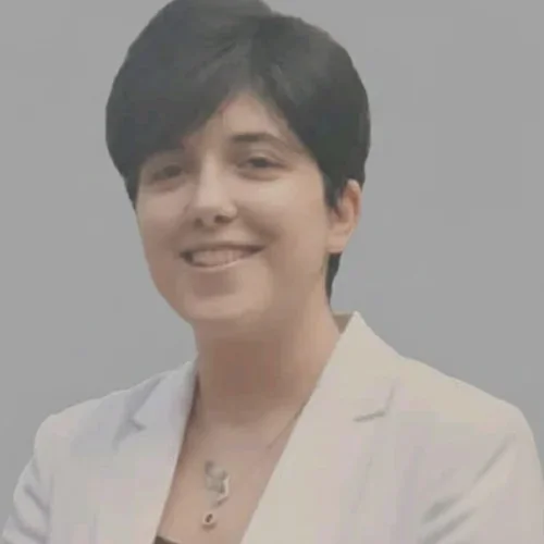 female with short, dark hair wearing white blazer