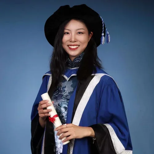 woman smiling wearing a graduation gown 