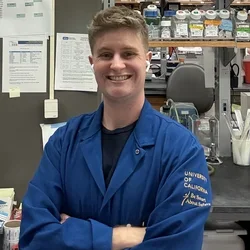 graduate student wearing blue lab coat 