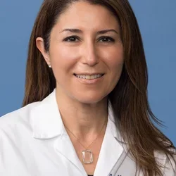 woman with long brown hair wearing white coat