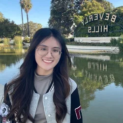 female with dark hair in front of lake