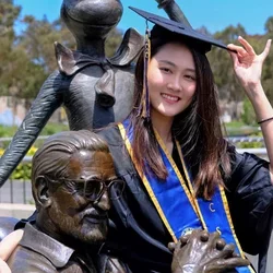woman in black graduation cap and gown with blue and yellow UCSD stole