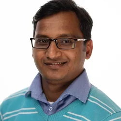 man with glasses and blue sweater with white stripes