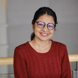 woman with dark hair pulled back wearing glasses and a red sweater