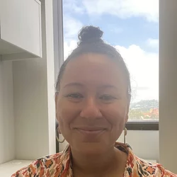 Woman in patterned shirt in front of window