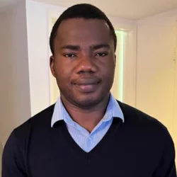 man wearing a black v-neck sweater with a blue collared shirt