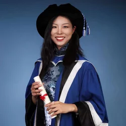 woman smiling wearing a graduation gown